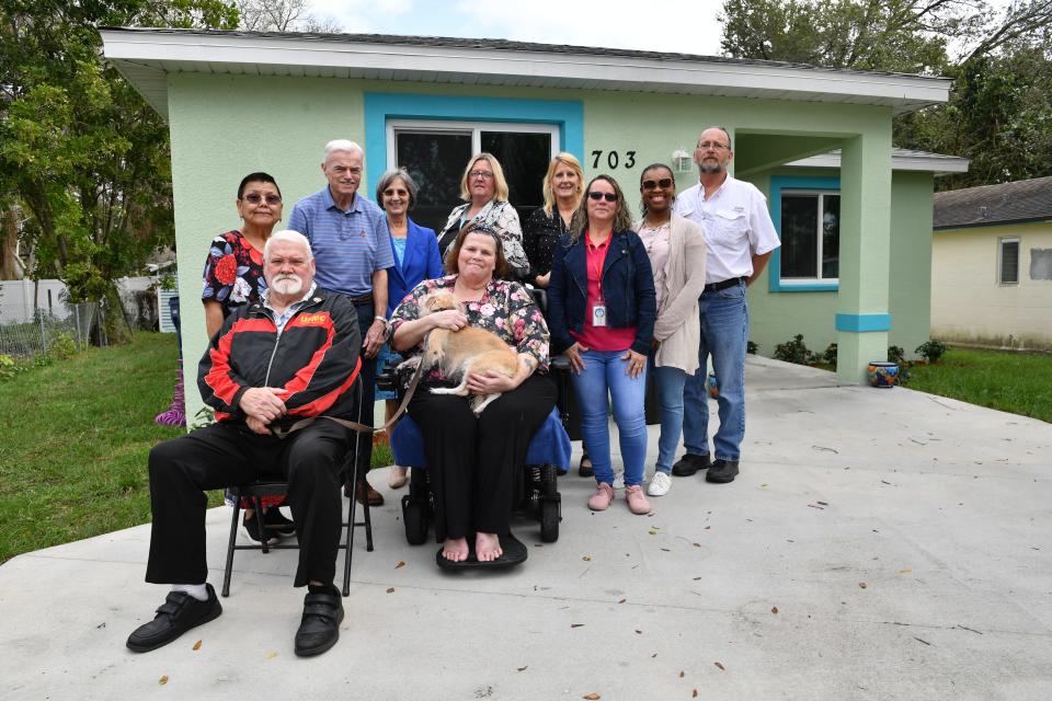 Homeowner Marie Salmons, center, poses for a photo in front of her newly rebuilt home, with some of the people who made it possible. From left, her brother Henry Tipp and friend Pauline Christ; Bill Ford with St. Vincent de Paul Society; Pamela Fields with Legal Aid of Manasota; and Nicole Milligan-Murray, Debbee Ash, Carmen Ruiz Morales, Jazmine Ward, Howard Jensen from the Manatee County Community & Veterans Services Development.