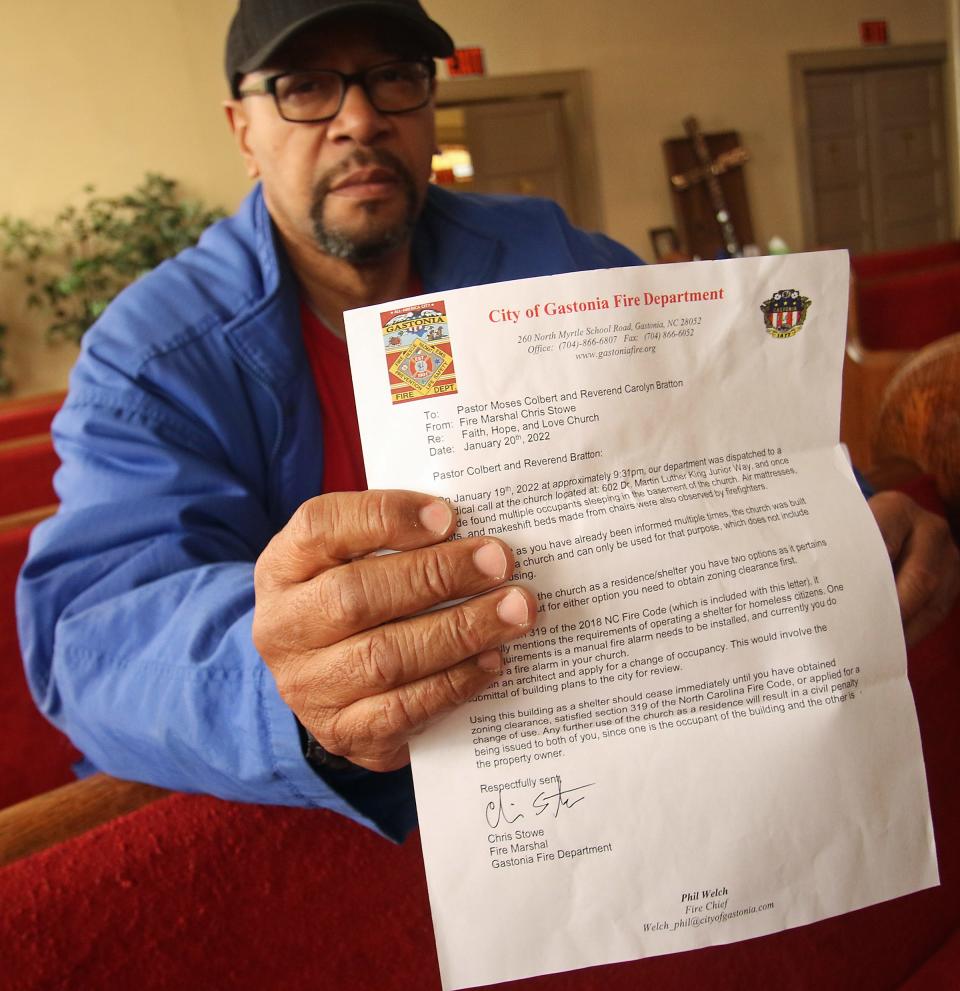 Pastor Moses Colbert hold a letter from the City of Gastonia Fire Department stating that his Faith, Hope and Love Church must cease using the church as a homeless shelter.