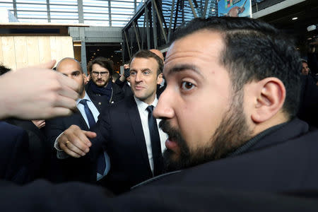 FILE PHOTO: French President Emmanuel Macron shakes hands while visiting the 55th International Agriculture Fair (Salon de l'Agriculture), as Elysee senior security officer Alexandre Benalla (R) looks on at the Porte de Versailles exhibition center in Paris, France, February 24, 2018. Ludovic Marin/Pool via Reuters