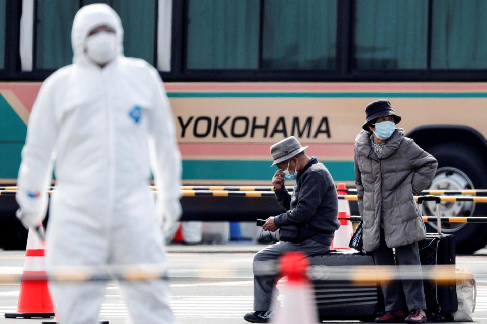 Passengers wait for transportation after leaving the coronavirus-hit Diamond Princess cruise ship docked at Yokohama Port (REUTERS)