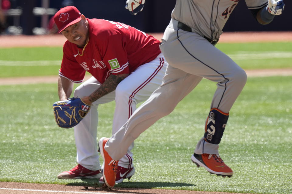 Toronto Blue Jays pitcher Yariel Rodriguez fields a ground ball before throwing out Houston Astros outfielder Yordan Alvarez, right, during the first inning of a baseball game in Toronto, Monday, July 1, 2024. (Frank Gunn/The Canadian Press via AP)