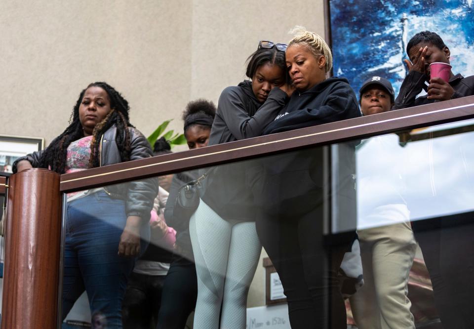 Star Arnold, left, Faith Pollard, Latonia Pollard, middle, and LaDonna Young, friends and family members of Porter Burks, look down at the news conference held inside Fieger Law in Southfield on Oct. 6, 2022.