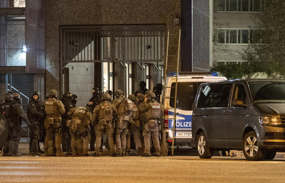 Armed police officers gather near the scene of a shooting in Hamburg, Germany on Thursday March 9, 2023. Shots were fired inside a building used by Jehovah's Witnesses in the northern German city of Hamburg on Thursday evening, and an unspecified number of people were killed or wounded, police said. (Daniel Bockwoldt/dpa via AP)