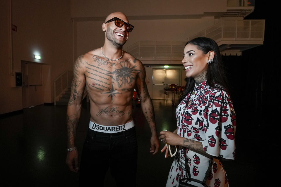 Marcell Jacobs, centre, and Nicole Daza, right, backstage being interviewed after the Dsquared2 men's Spring Summer 2023 collection presented in Milan, Italy, Friday, June 17, 2022. (AP Photo/Luca Bruno)