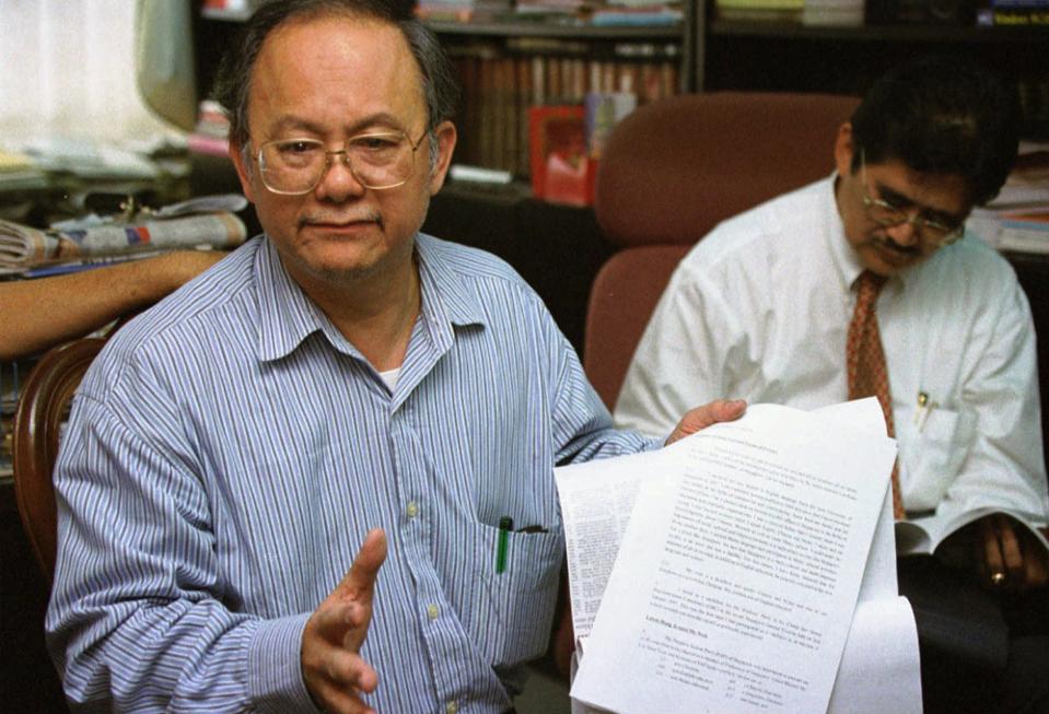 Singaporean politician and lawyer Tang Liang Hong, left, and his Malaysian lawyer Abdul Razak Ahmad meet with members of the press in Johor Bahru, Malaysia Tuesday, March 11, 1997. Tang, who fled Singapore, was found guilty of defaming Singapore's prime minister and other leaders and faces disciplinary action that could strip him of his license. The lawsuits stem from the contention that Tang called the leaders liars when he rejected their allegations that he was an anti-Christian Chinese nationalist bigot who could threaten the racial harmony of Singapore.  (AP Photo/Bernama)