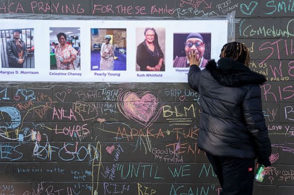 PHOTO: Kimberly Johnson, of Buffalo, places her hand on a photo of the late Hayward Patterson, at makeshift memorial across the street from the scene of a mass shooting at Tops Friendly Market, May 19, 2022 in Buffalo, New York. (Kent Nishimura/Los Angeles Times via Getty Images)