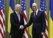 U.S. Vice President Joe Biden (L) shakes hands with Ukrainian Prime Minister Arseniy Yatsenyuk during their meeting in Kiev, November 21, 2014. REUTERS/Valentyn Ogirenko