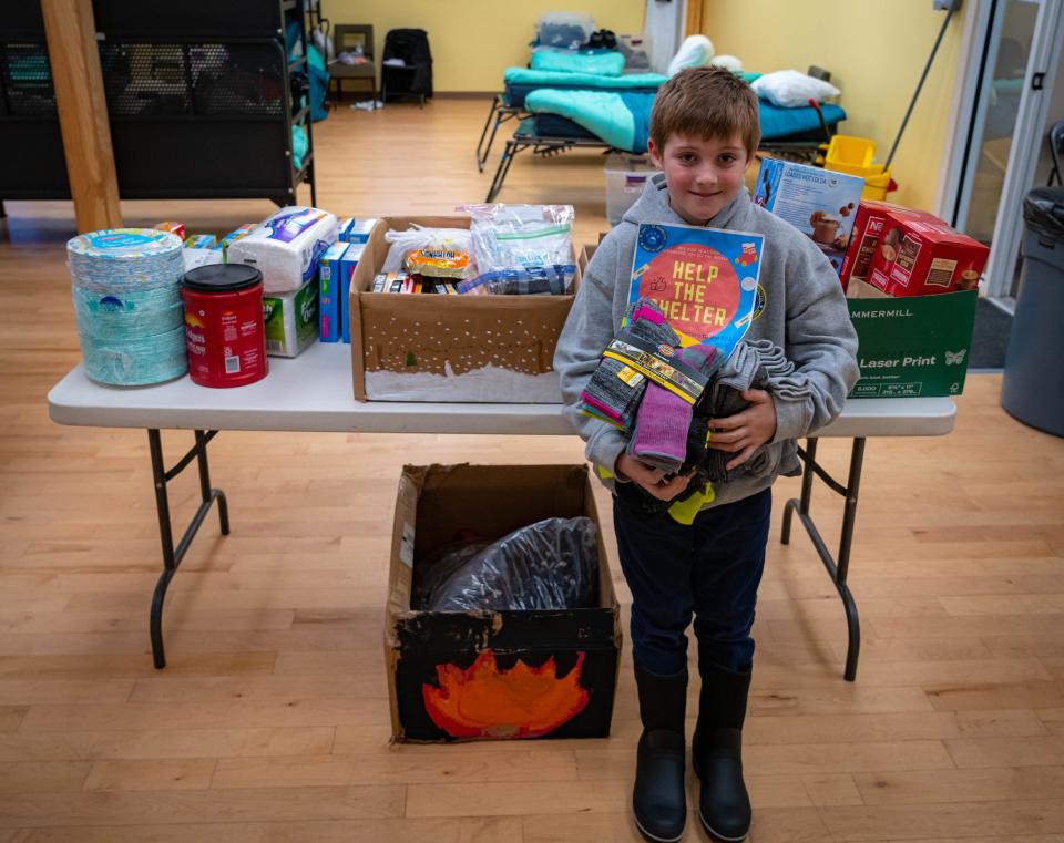 Benjamin Deely, a fourth-grader at Barrington Elementary School, stands in front of several boxes of donated goods, which he and his family recently delivered to the Willand Warming Center of Strafford County in Somersworth. Ben collected the goods during a donation drive at his school earlier this month.