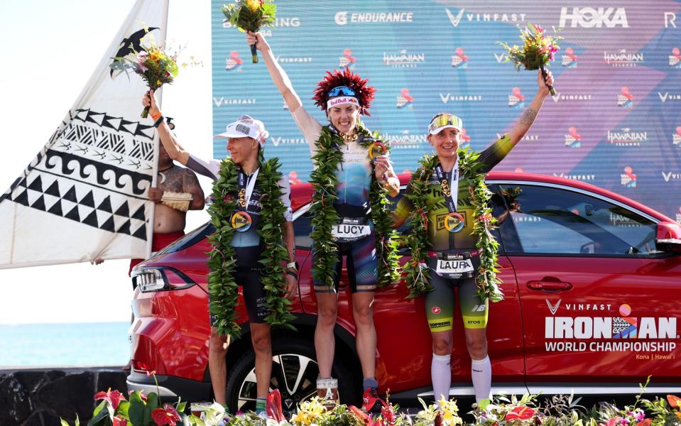 Great Britain's Lucy Charles-Barclay (1st) and Germany's Laura Philipp (3rd) celebrate after finishing the VinFast IRONMAN World Championship on October 14, 2023 in Kailua Kona, Hawaii.