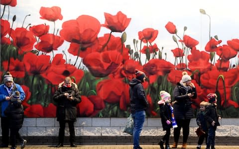  Leicester City's fans stand next to a giant poppy mural ahead of the English Premier League soccer match between Leicester City v Arsenal  - Credit: FACUNDO ARRIZABALAGA/EPA-EFE/REX