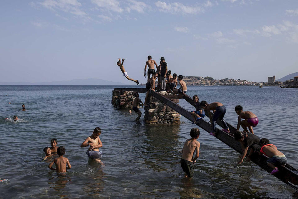 2020年9月12日，希臘萊斯沃斯島，被毀的莫里亞難民營的孩子在海邊跳水。