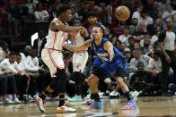 Miami Heat guard Kyle Lowry, left, passes the ball as Orlando Magic guard Cole Anthony defends during the first half of an NBA basketball game, Friday, Jan. 27, 2023, in Miami. (AP Photo/Lynne Sladky)