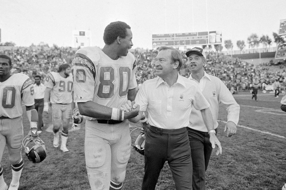 FILE - San Diego Chargers head coach Don Coryell congratulates Chargers tight end Kellen Winslow (80) after having a great day against the Oakland Raiders at the Oakland Coliseum, Nov. 23, 1981. The Chargers beat the Raiders 55-21. Innovative offensive coach Don Coryell, who helped usher in the modern passing game to the NFL, was picked as a finalist for the Pro Football Hall of Fame’s class of 2023. The former Chargers and Cardinals coach was announced Wednesday, Aug. 24, 2022, as the candidate from a group of 12 coaches and contributors.(AP Photo/Paul Sakuma, File)