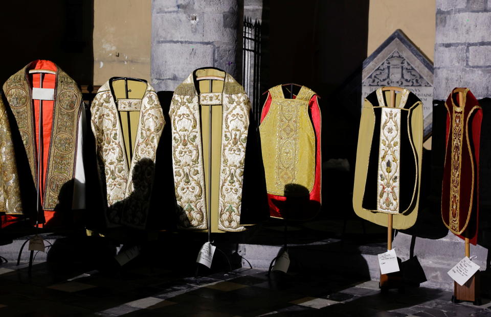 The shadows of volunteer models who attend in the backstage before they walk in around 30 religious garbs, some dating back to the 15th century, in a runway show are seen at the Tournai cathedral, Belgium, November 10, 2021. Picture taken November 10, 2021.   REUTERS/Pascal Rossignol