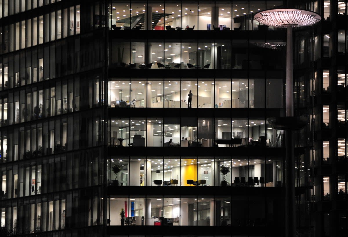 Office workers in a building along the River Thames (PA)