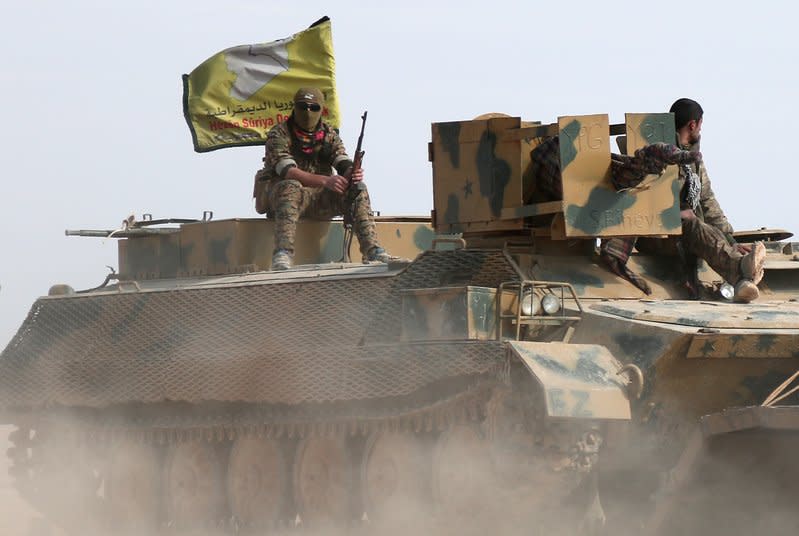 Syrian Democratic Forces fighters sit on a vehicle in the north of Raqqa city, Syria. REUTERS/Rodi Said