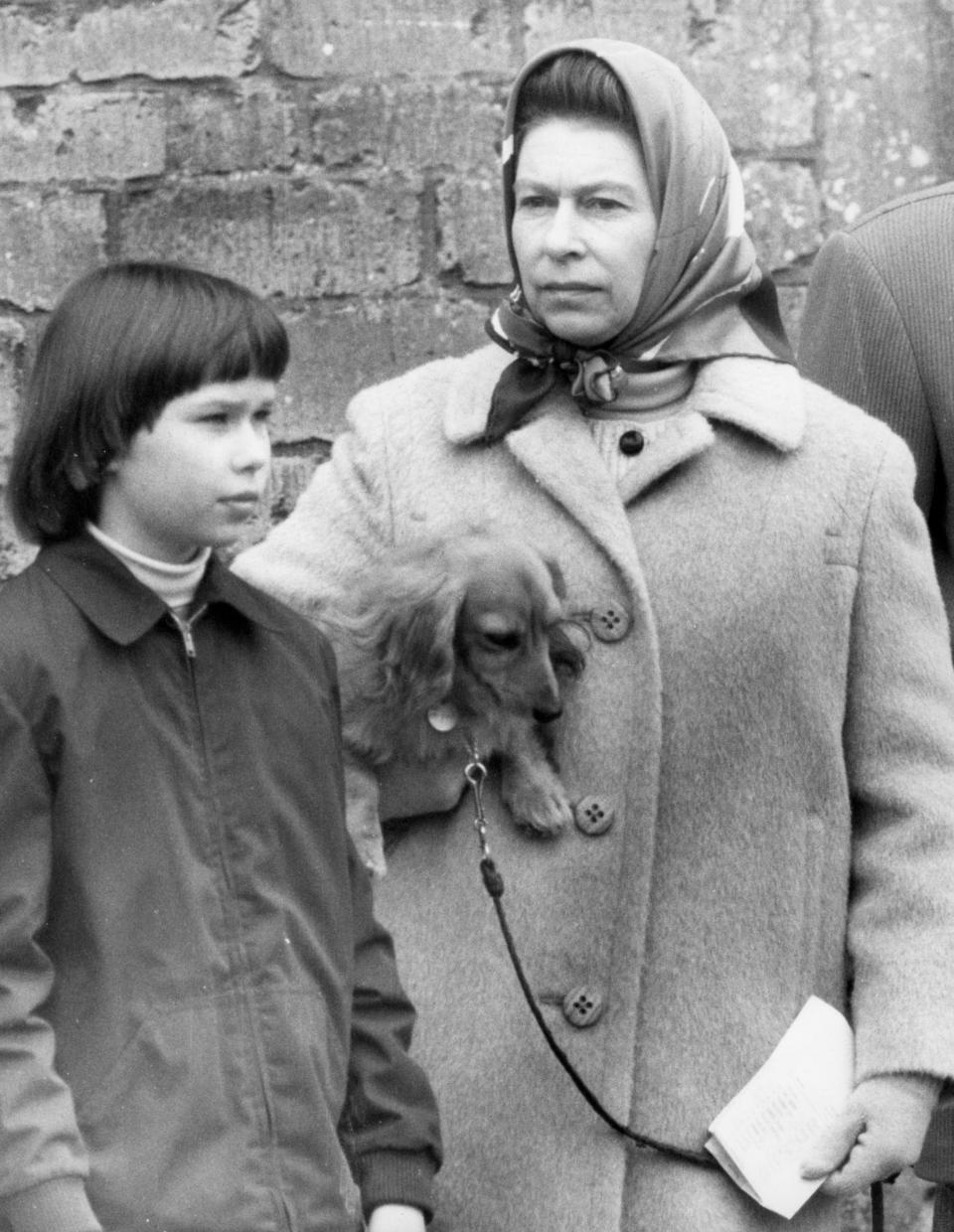 Queen Elizabeth II holds a dachshund under her arm as she watches the veterinary inspection on the last day of the Badminton Horse Trials. With her is Lady Sarah Armstrong-Jones, 11, daughter of Princess Margaret.