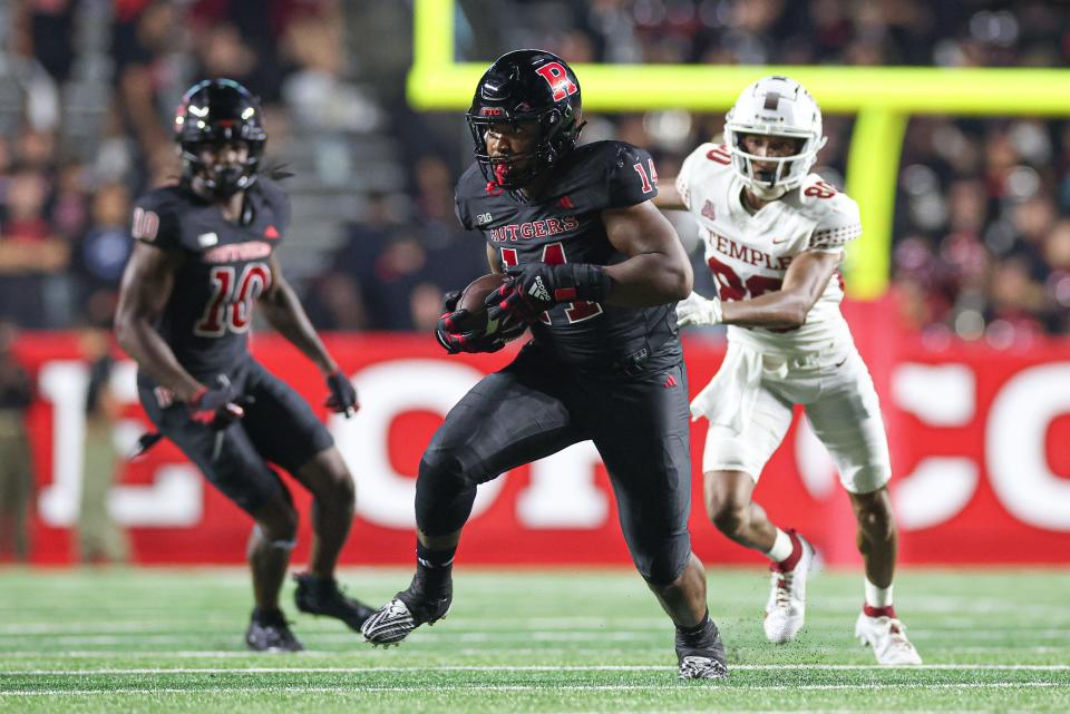 Sep 9, 2023; Piscataway, New Jersey, USA; Rutgers Scarlet Knights defensive lineman Jordan Thompson (14) returns an interception during the second half against the Temple Owls at SHI Stadium. Mandatory Credit: Vincent Carchietta-USA TODAY Sports