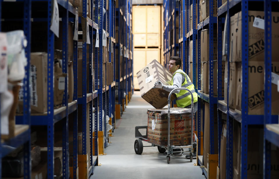 Lovespace warehouse worker Pawel Mazur unloads boxes from a trolley to place them into their allocated zones at the warehouse in Dunstable, England Monday, Jan. 14, 2019. Lovespace, which collects boxes from customers, stores them and then returns the goods when needed, says revenue from businesses doubled over the past year as enterprises large and small began stockpiling inventory because of concerns they will be cut off from suppliers if Britain leaves the European Union without an agreement on future trading relations. (AP Photo/Alastair Grant)