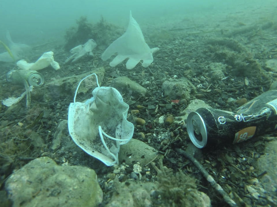 This photo taken on May 21, 2020 and providedWednesday May 27, 2020 by environmental group Operation Mer Propre (Operation Clean Sea) shows plastic gloves and face masks and other wastes off Antibes, southern France. A French environmental group found this virus-era detritus littering the Mediterranean floor near the French Riviera resort of Antibes, and is trying to raise awareness and clean it up. (Operation Mer Propre via AP)