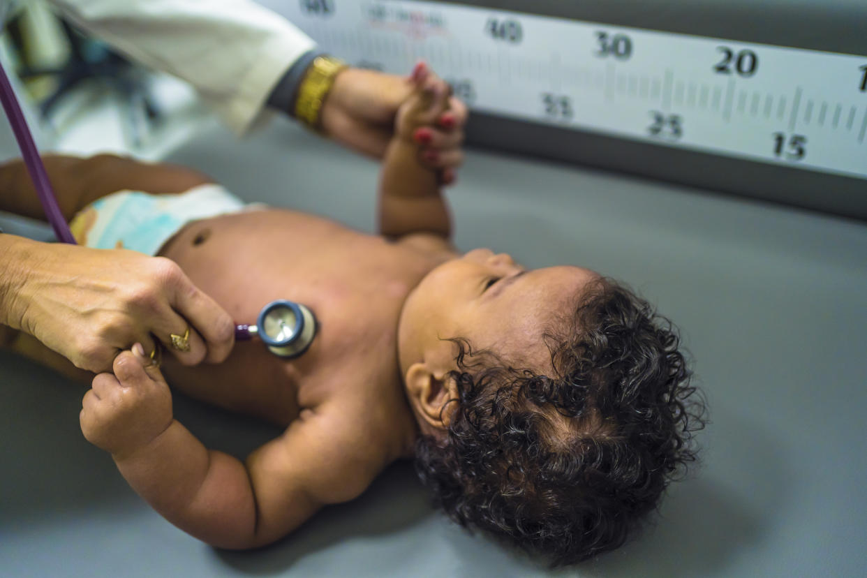 Pediatrician examining baby boy with a stethoscope at hospital