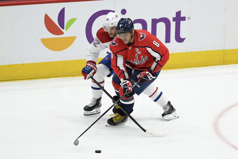Washington Capitals left wing Alex Ovechkin (8), of Russia, battles for the puck with Montreal Canadiens left wing Jonathan Drouin (92) during the first period of an NHL hockey game, Thursday, Feb. 20, 2020, in Washington. (AP Photo/Nick Wass)