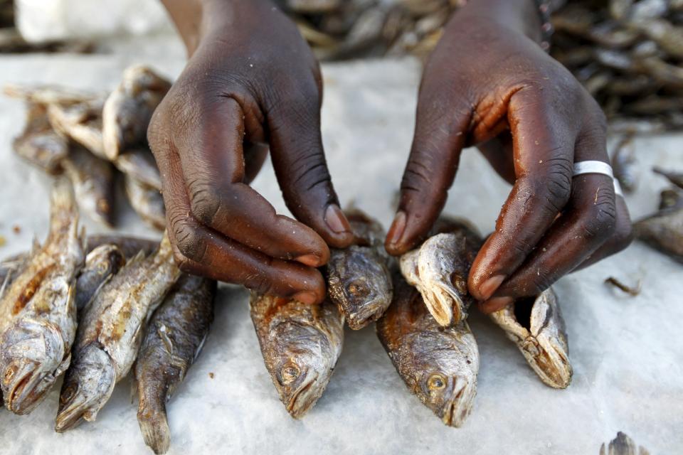 Patricia Anyango arregla los pescados que vende en el mercadillo del pueblo. REUTERS/Thomas Mukoya