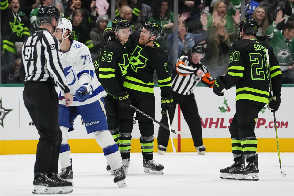 Dallas Stars center Joe Pavelski, center, celebrates his power play goal with defenseman Thomas Harley (55) and defenseman Ryan Suter (20) as Tampa Bay Lightning center Anthony Cirelli (71) skates by during the second period of an NHL hockey game, Saturday, Dec. 2, 2023, in Dallas. (AP Photo/Julio Cortez)