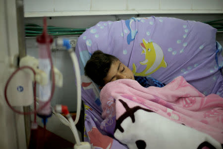 A Palestinian patient sleeps as he undergoes kidney dialysis at Shifa hospital in Gaza City April 24, 2017. REUTERS/Mohammed Salem