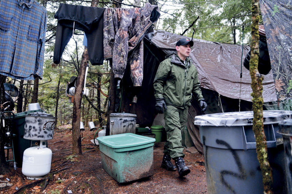 ROME, ME - APRIL 9: District Game Warden Aaron Cross exits Christopher Knight's camp Tuesday April 9, 2013 in a remote, wooded section of Rome after police inspected the site where Knight is believed to have lived since the 1990s.  Police believe Knight, who went into the woods near Belgrade in 1986, was a hermit who committed hundreds of burglaries to sustain himself. (Photo by Andy Molloy via Getty Images)