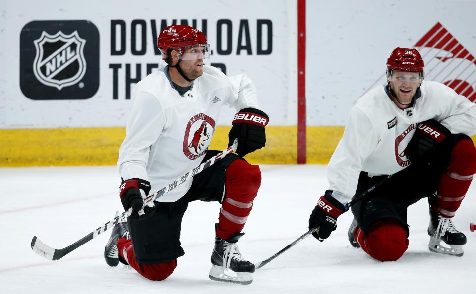 Arizona Coyotes right wing Phil Kessel, left, and Coyotes right wing Christian Fischer (36) take a break during NHL hockey practice at Gila River Arena Monday, July 13, 2020, in Glendale, Ariz. (AP Photo/Ross D. Franklin)