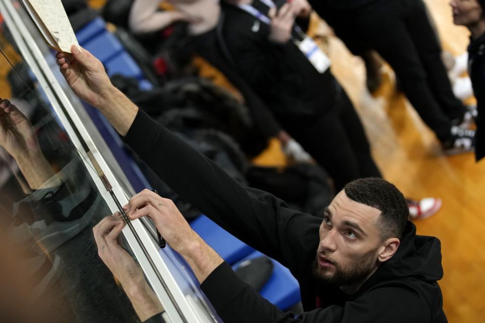 Chicago Bulls Zach LaVine signs autographs after a training session on the eve of the NBA basketball game between Chicago Bulls and Detroit Pistons, in Levallois-Perret, outside Paris, Wednesday, Jan. 18, 2023. (AP Photo/Christophe Ena)