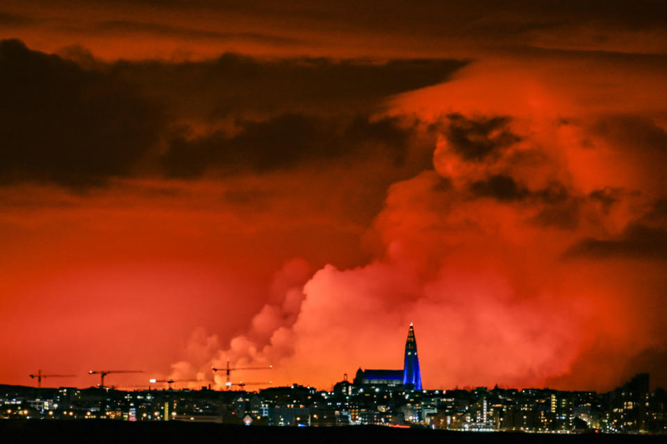 The skyline of Reykjavik is against the backdrop of orange coloured sky due to molten lava flowing out from a fissure on the Reykjanes peninsula north of the evacuated town of Grindavik, western Iceland on March 16, 2024. Lava spewed Saturday from a new volcanic fissure on Iceland's Reykjanes peninsula, the fourth eruption to hit the area since December, authorities said. (Photo by Halldor KOLBEINS / AFP) (Photo by HALLDOR KOLBEINS/AFP via Getty Images)