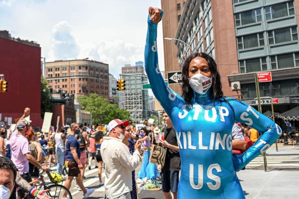 <p>Singer Mila Jam poses in a jumpsuit that reads, 'stop killing us' at the Queer Liberation March for Black Lives & Against Police Brutality.</p>