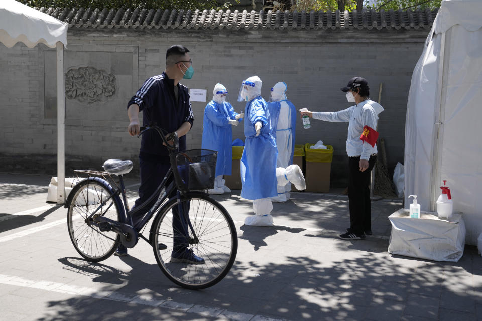 Workers disinfect before ending their shift at a COVID mass testing site on Sunday, May 15, 2022, in Beijing. (AP Photo/Ng Han Guan)