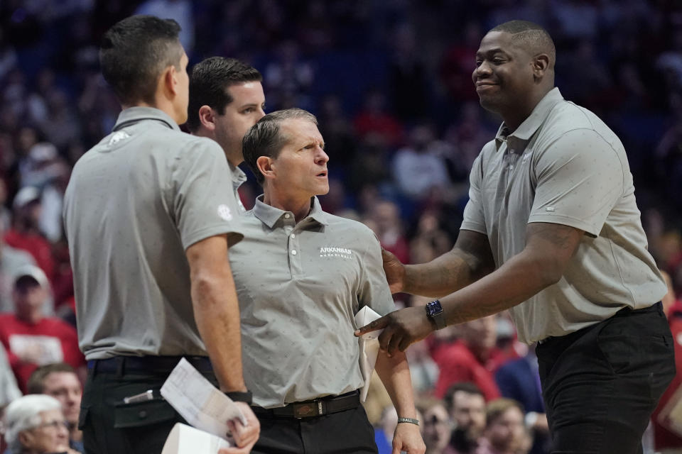 Arkansas head coach Eric Musselman, center, is held back from the officials after being ejected in the second half of an NCAA college basketball game against Oklahoma, Saturday, Dec. 11, 2021, in Tulsa, Okla. (AP Photo/Sue Ogrocki)