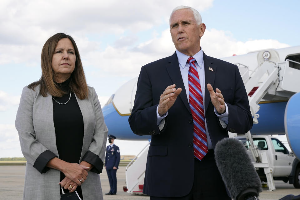 Vice President Mike Pence speaks to members of the media at Andrews Air Force Base, Md., Monday, Oct. 5, 2020, as he leaves Washington for Utah ahead of the vice presidential debate schedule for Oct. 7. At left is Karen Pence. (AP Photo/Jacquelyn Martin)