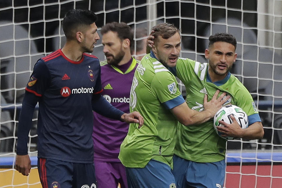 Seattle Sounders midfielder Cristian Roldan, right, greets forward Jordan Morris, second from right, after Morris assisted him on a goal that was called back due to Morris being off-sides during the second half of an MLS soccer match against the Chicago Fire, Sunday, March 1, 2020, in Seattle. (AP Photo/Ted S. Warren)