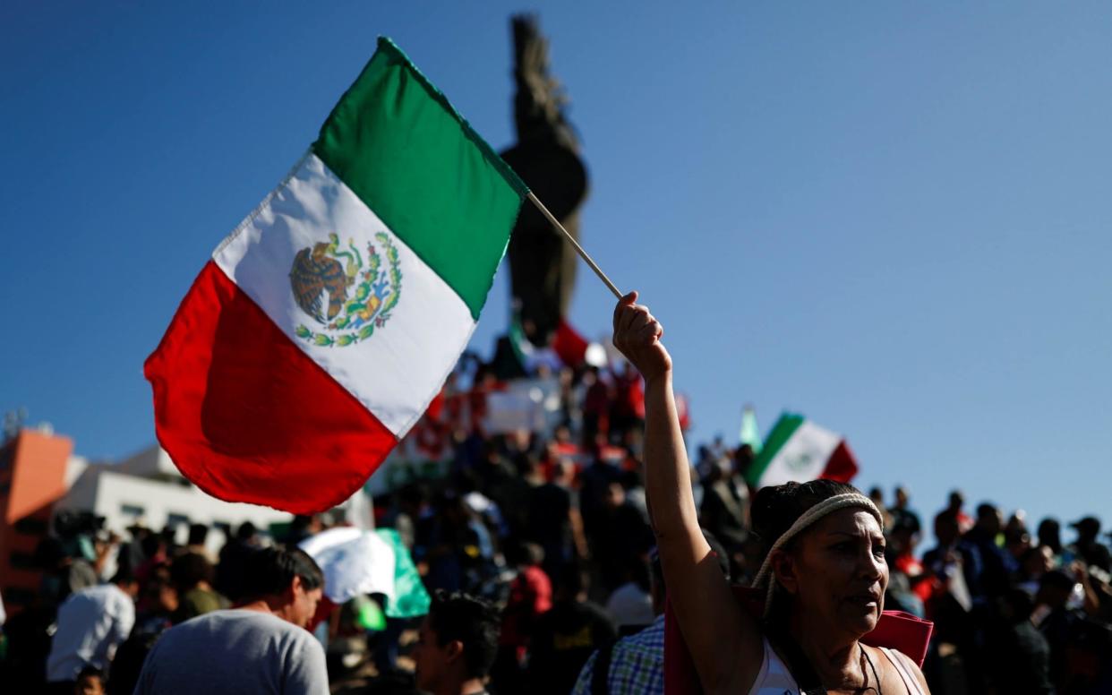 Protesters in Tijuana on Sunday, at the statue of Aztec warrior Cuauhtemoc, demanding that the migrant caravan turn back - REUTERS