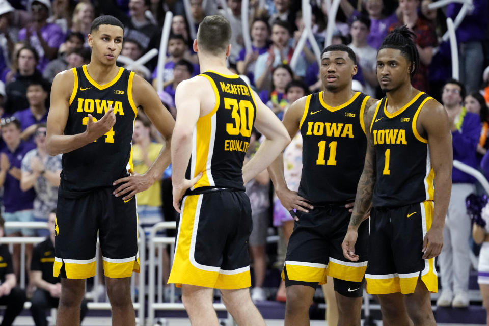 Iowa forward Kris Murray, left, talks with guards Connor McCaffery (30), Tony Perkins (11) and Ahron Ulis during the second half of an NCAA college basketball game against Northwestern in Evanston, Ill., Sunday, Feb. 19, 2023. (AP Photo/Nam Y. Huh)