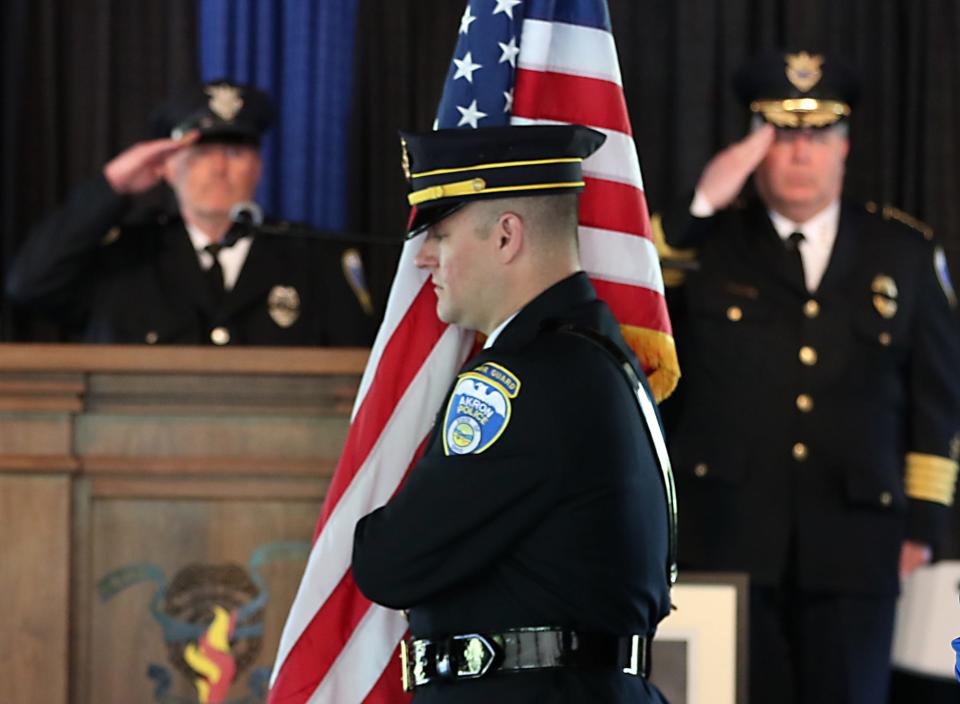 Officer Clay Cozart, president of the Fraternal Order of Police Akron Lodge 7, and Akron Police Chief Steve Mylett salute as members of the Honor Guard bring in the colors during the Akron Police Memorial Day service Wednesday.