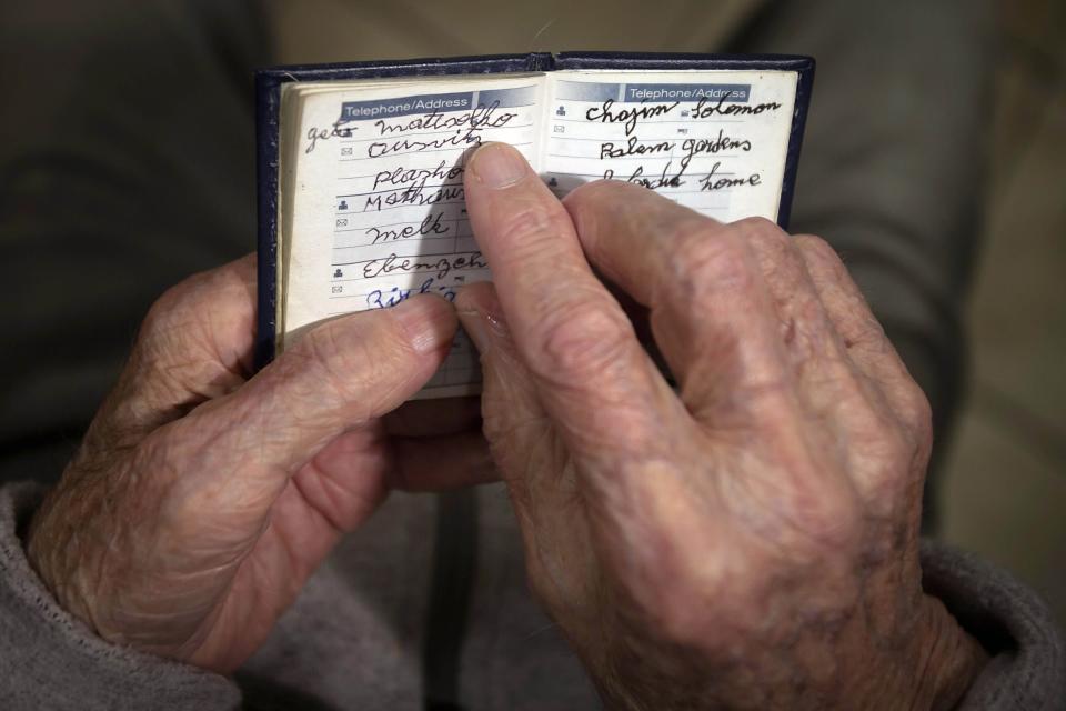 90 year old Holocaust survivor Hy Abrams points at the word "Auschwitz" as he poses for a photo with a book that he carries with him everyday that documents all the different concentration camps he was held in during the second World War, in the Brooklyn borough of New York January 15, 2015. In a little leather book, the kind some men use to list lovers, Holocaust survivor Abrams keeps the names that still haunt him: Auschwitz, Plaszow, Mauthausen, Melk and Ebensee. It has been 70 years since the Soviet army liberated the Auschwitz concentration camp in Poland, where Abrams was taken at age 20 by German Nazi soldiers and separated from his mother, father, brother and three sisters. Picture taken January 15, 2015. To match AUSCHWITZ-ANNIVERSARY/USA REUTERS/Carlo Allegri (UNITED STATES - Tags: SOCIETY ANNIVERSARY CONFLICT)