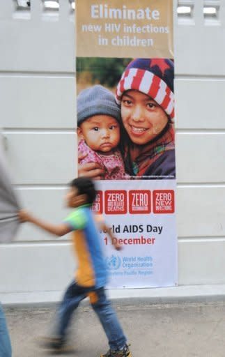 A boy walks along a street past a world AIDS day poster displayed in front of the World Health Organization (WHO) regional office in Manila on December 1. The Philippines is struggling to deal with a worsening HIV-AIDS problem, with far too little money being spent on reversing a steady rise in infection rates, health experts warn