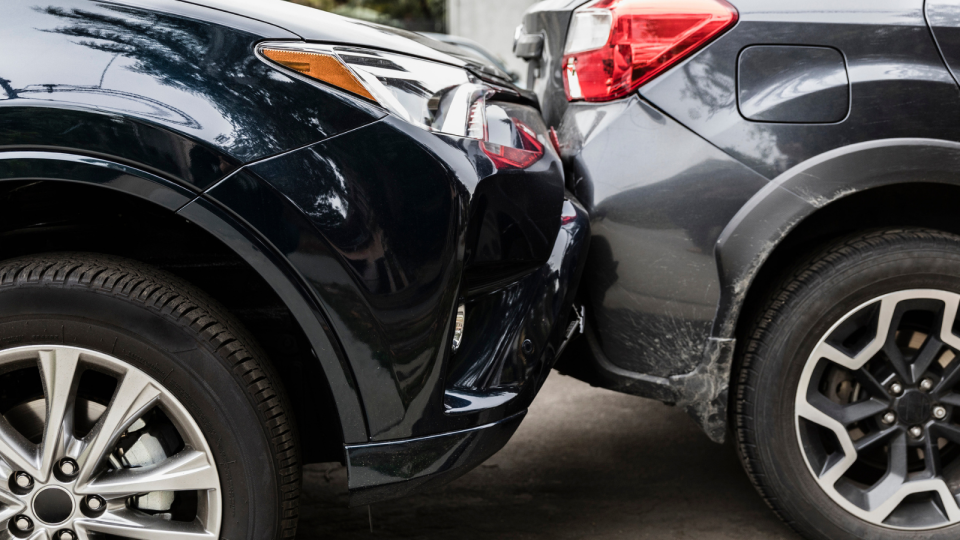 Close image of two cars in accident with one rear-ending the other. 