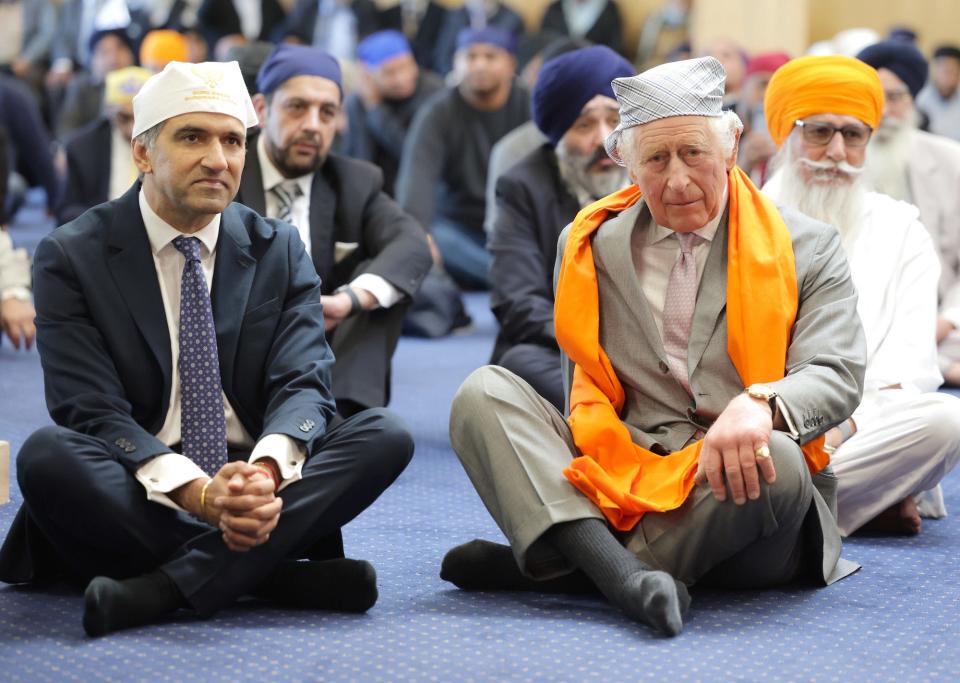 King Charles III sits on the floor in the Prayer Hall with Professor Gurch Randhawa on Guru Nanak Gurdwara on December 6, 2022.