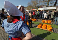 Sellers stand next Gouda wheels at the cheese market in Gouda, Netherlands April 18, 2019. REUTERS/Yves Herman