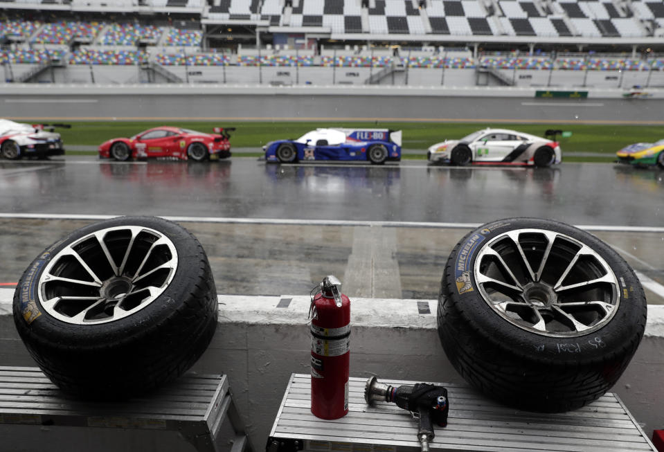 Tires sit idle in a pits stall overlooking pit road where the cars were parked after the IMSA 24-hour race was red-flagged because of rain at Daytona International Speedway, Sunday, Jan. 27, 2019, in Daytona Beach, Fla. (AP Photo/John Raoux)