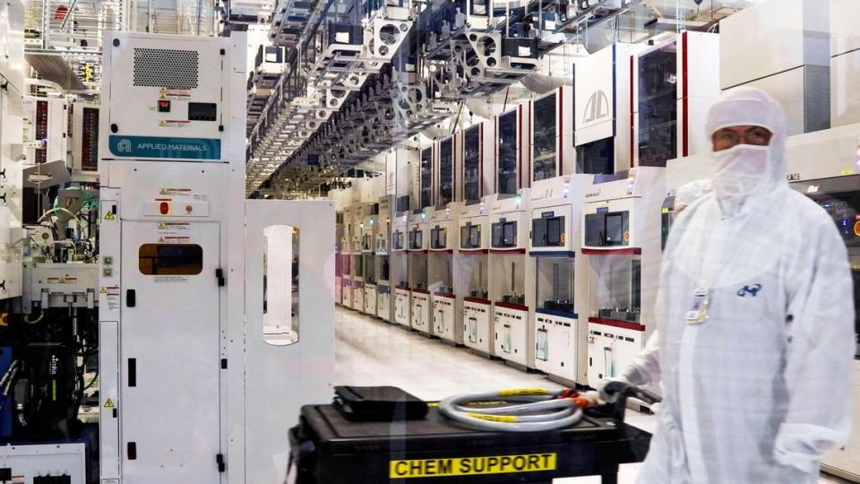 A Micron employee, clad in a white “bunny suit,” moves through a clean room at a research-and-development fab on the memory-chip maker’s Southeast Boise campus in 2022.