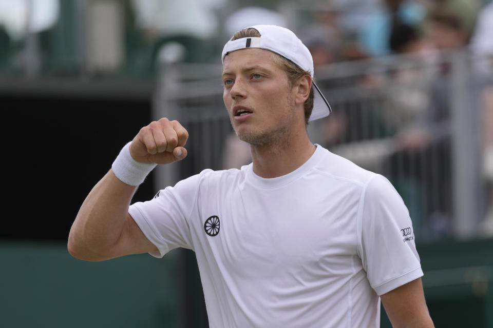 Tim van Rijthoven of the Netherlands celebrates winning the first set against Georgia's Nikoloz Basilashvili in a third round men's singles match on day five of the Wimbledon tennis championships in London, Friday, July 1, 2022. (AP Photo/Alastair Grant)