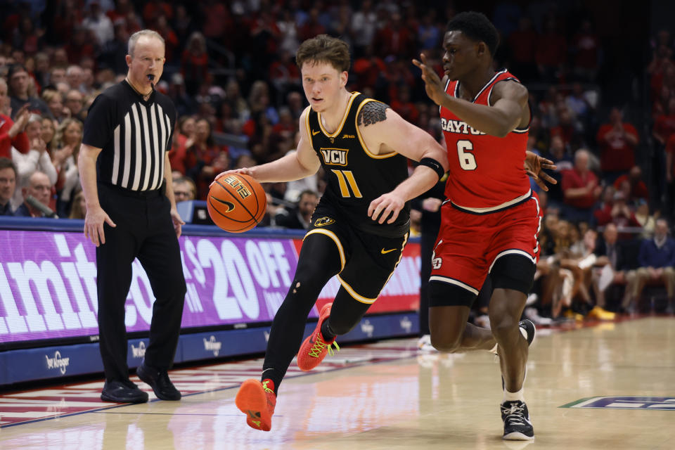 Virginia Commonwealth's Max Shulga (11) dribbles as Dayton's Enoch Cheeks (6) defends during the first half of an NCAA college basketball game Friday, March 8, 2024, in Dayton, Ohio. (AP Photo/Jay LaPrete)